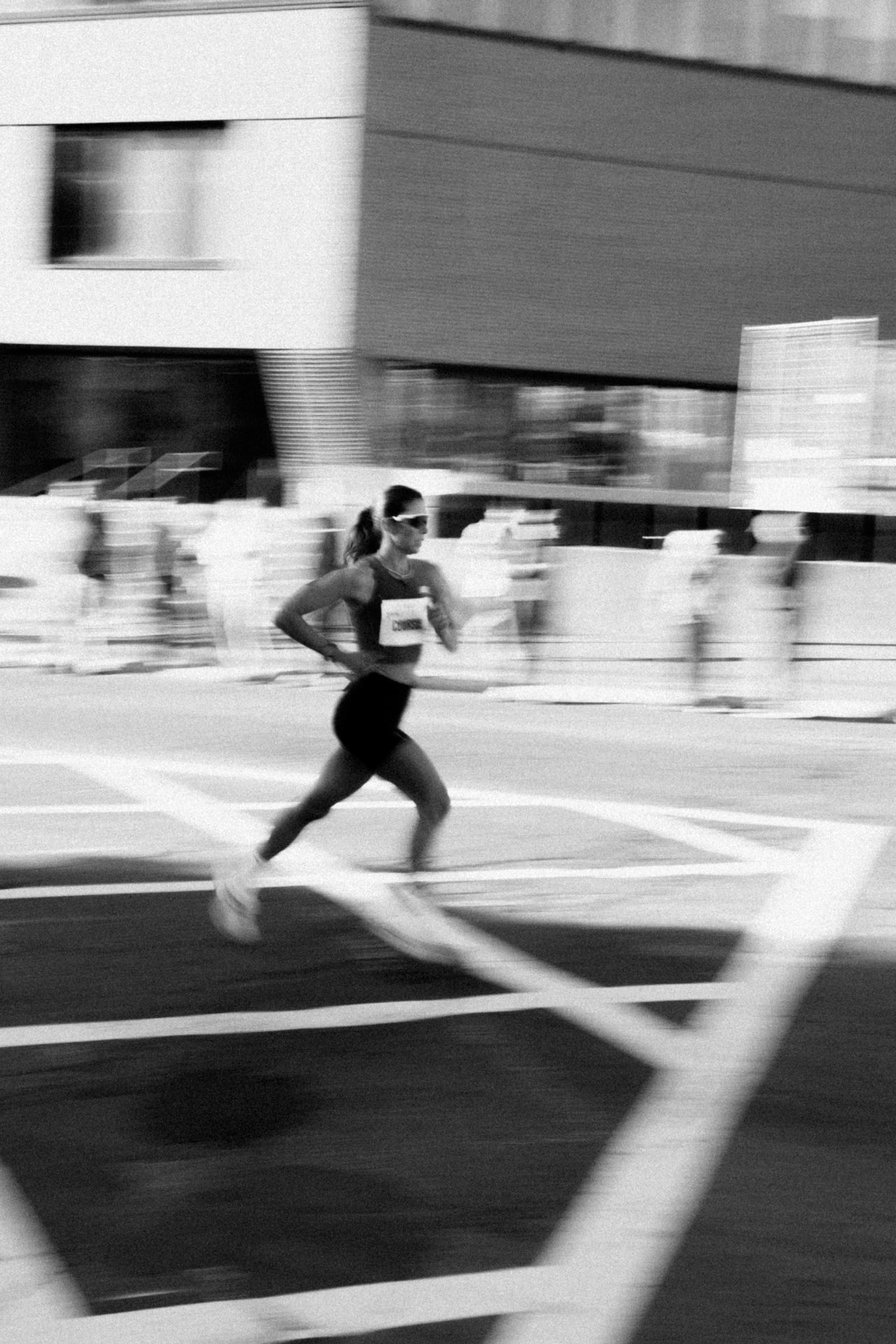 Solo runner in motion through a city street, black and white